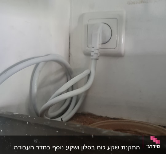 תקע חשמלי לבן מחובר לשקע בקיר